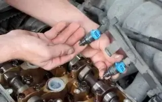 person holding up fuel injector for testing